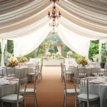 Experience exquisite Wedding Tent Chair & Table Rentals at a stunning outdoor ceremony with elegant decor.