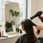 Professionelle Haarstylistin verwendet den Laifen Föhn in einem eleganten Salon.